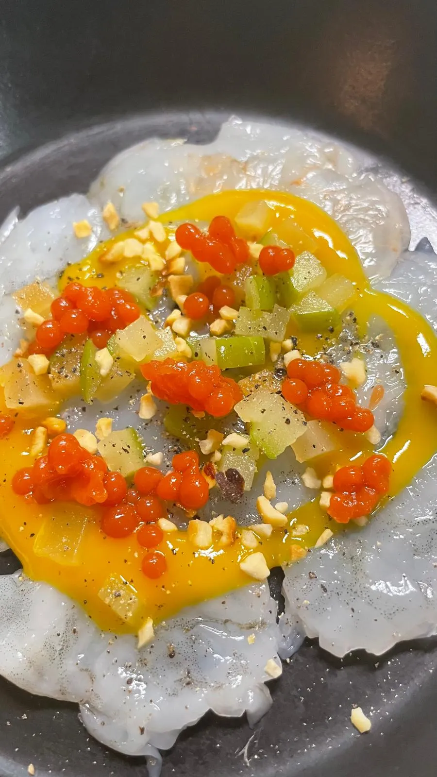 Carpaccio de crevettes, sauce à la mangue, œufs de truite et noisettes