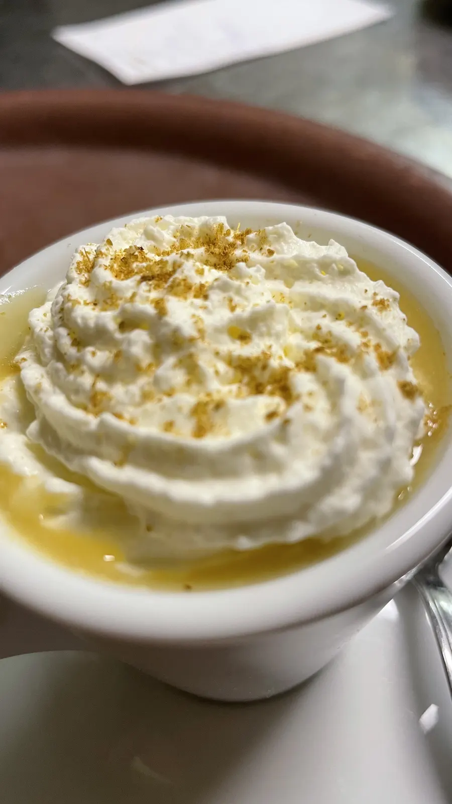 Cappuccino gourmand — Crème fouettée et éclats dorés, servi en tasse.