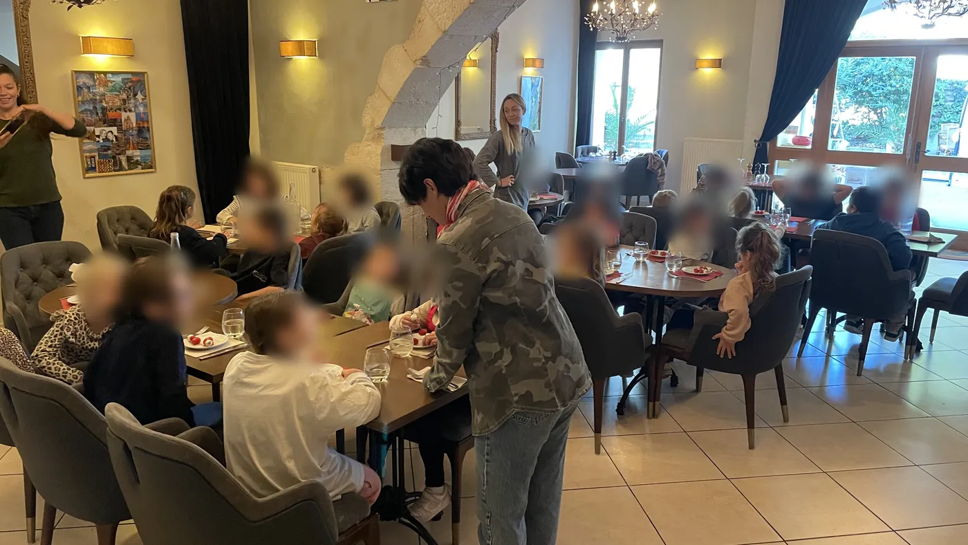 La salle du restaurant repeinte en jaune et bleu, sous l'arche de pierre